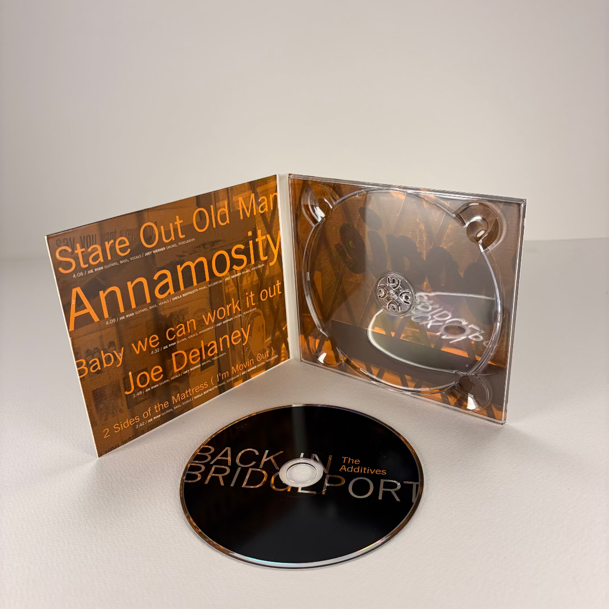 CD with cover featuring text and a logo on a white background